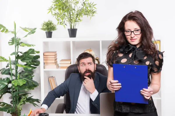 Manager verantwortlich für die Verwaltung Büro. Sinnlicher Büroleiter mit Chef im Hintergrund. Projektmanager mit sexy Look. entzückende Sekretärin hält Ordner im Manager-Büro — Stockfoto