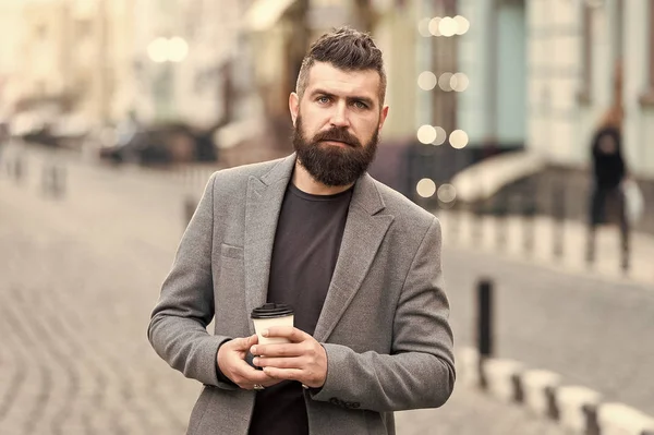 Man bearded hipster drink coffee paper cup. Businessman well groomed enjoy coffee break outdoors urban background. Thoughtful but relaxed. Walk and enjoy fresh hot coffee. Involved in relaxation — Stock Photo, Image