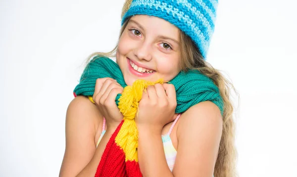帽子とスカーフは暖かく保ちます。どの生地がこの冬一番暖かく保つでしょう。女の子長い髪幸せな顔白い背景。子供は暖かい柔らかいニットブルーの帽子と長いスカーフを着用します。ウォームウールアクセサリー — ストック写真