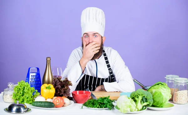 Culinária colorida. Chef profissional em uniforme de cozinheiro. homem barbudo cansado cozinhar na cozinha. Dieta com alimentos orgânicos. Legumes frescos. Comida saudável e vegetariana. Vitamina. homem usar utensílios de cozinha — Fotografia de Stock