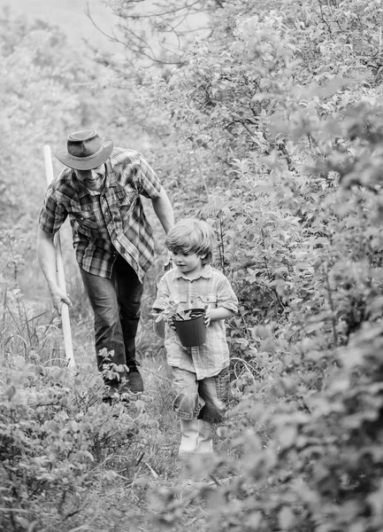 花を植える。植物の栽培。水やり缶とシャベルで自然の中で少年と父。お父さんは息子のケア植物を教えています。アーバーの日。木を植える植樹の伝統。庭の小さなヘルパー — ストック写真