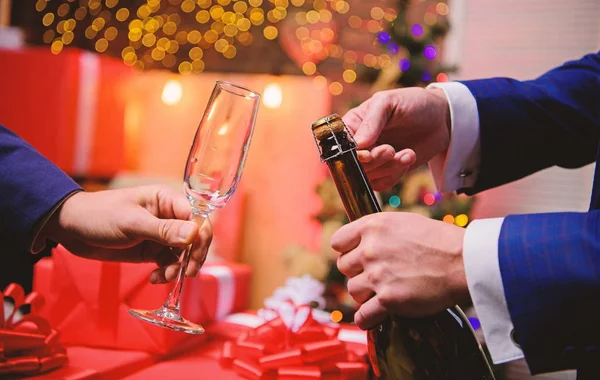 Şampanya ya da köpüklü şarap iç. Yeni yılı şampanyayla kutlayalım. Yılbaşından önceki son dakika. Yeni yıl geri sayımı. Şampanya şişesini açan eller ve arka planda cam süslemeler. — Stok fotoğraf