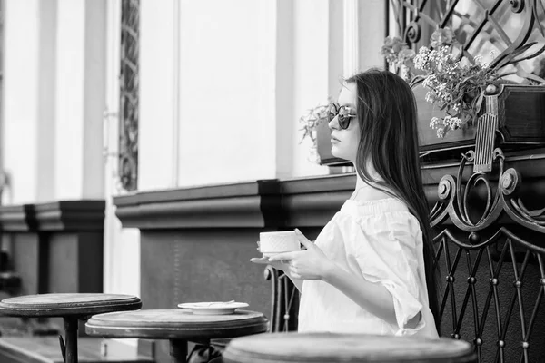 Kobieta w okularach pije kawę na świeżym powietrzu. Dziewczyna zrelaksować się w filiżance cappuccino kawiarni. Dawka kofeiny. Kawa na energetyczny udany dzień. Śniadanie w kawiarni. Dziewczyna lubi poranną kawę. Czekam na randkę. — Zdjęcie stockowe