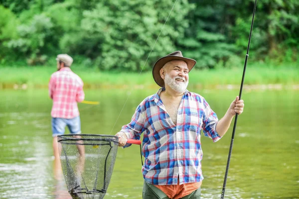 Activité et passe temps. Heureux les gens joyeux. Maître baiter. Pêcheur avec canne à pêche. Pêche lac d'eau douce étang rivière. Des hommes barbus attrapant du poisson. Homme mûr avec ami pêche. Vacances d'été — Photo