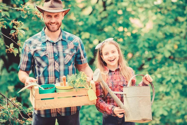 family farm. spring village country. ecology. Watering can and shovel. little girl and happy man dad. earth day. father and daughter on ranch. Beautiful florist at work. hello summer