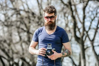 Fotoğrafçı vintage kamera tutun. Modern blogcu. İçerik oluşturucu. Adam sakallı hipster fotoğrafçısı. Sakallı ve bıyıklı fotoğrafçı. Uzun sakallı, fotoğraf çeken adam. Manuel ayarlar
