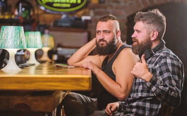 Barda Cuma rahatlama. Hipster sakallı adam Bar tezgahında boş harcama. Bar tezgahında içki ısmarlayabilirsiniz. Akıllı telefon olan erkekler barda rahatlatıcı. Mobil bağımlılık kavramı. Cep telefonu her zaman benimle