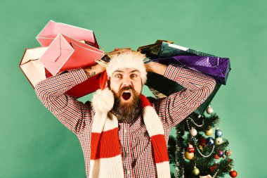 Yeşil arka planda sakallı ve korkmuş yüzlü bir adam.