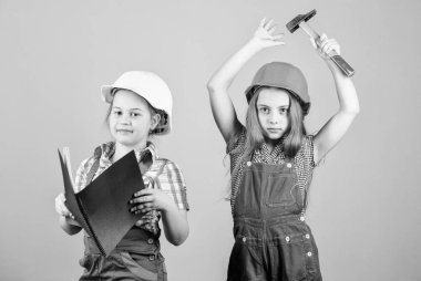 mutlu çocuklar. Gelecekteki kariyeri. küçük kızlar atölyede birlikte tamir. İşçi Bayramı 1 Mayıs. Tablet ve çekiçle miğferli küçük çocuklar. Foreman müfettişi. Onarım. Küçük kızlar. çalışan küçük kızlar