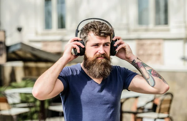 Man bearded hipster headphones listening music. Hipster enjoy excellent sound song in earphones. Walking with music. Music beat for energetic mood. Rhythm for walk. Excellent music playlist
