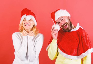 Çift kutlamak kış tatil Noel partisi. Sakal ve kadın santa şapka kırmızı arka planı olan adam. Noel maskeli balo karnival kavramı. Çift neşeli yüzü Noel kutlaması. Noel Baba kostüm Kiralama