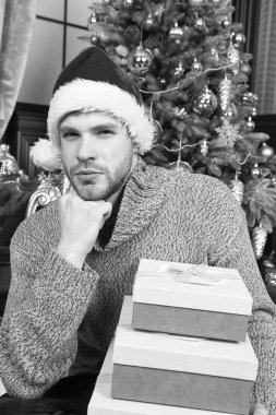 Noel düşüncelerinde kaybettim. Xmas hediye kutuları ile mutlu bir adam. Adam evde Noel kutluyor. Santa şapka adam Noel hediyelerini tutun. Teslimat Noel hediyeleri. En iyi Noel hediyesi