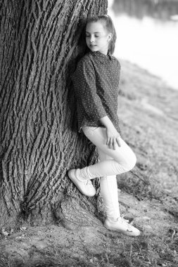 Sakin ve huzurlu. Yaşam dengesi. Huzurlu bir ruh hali. Sadece iyi titreşimler. Kız küçük sevimli çocuk ağaç gövdesinde huzur ve huzur tadını çıkarın. Gücün yeri. Huzurlu bir yer. Huzuru bulun ve doğada rahatlayın