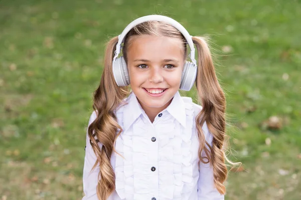 機会を拡大する。音楽に触発されました。音楽を聴く女の子近代的なガジェット。現代の技術を使用して愛らしい子供。現代の子供完璧なサウンド。ワイヤレスヘッドセットを持つかわいい子供。ステレオヘッドフォン — ストック写真