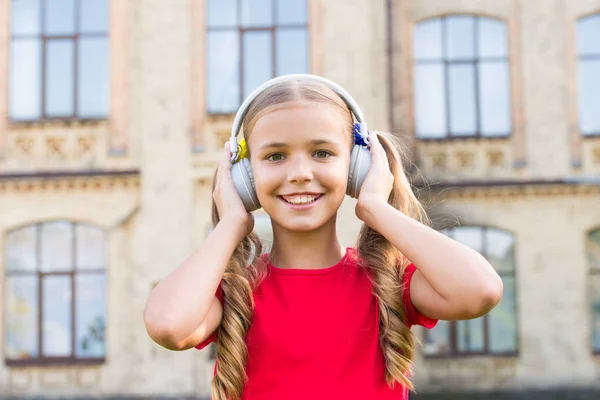 Αναπτύξτε ευκαιρίες. Εμπνευσμένο από τη μουσική. Κορίτσι ακούγοντας μουσική σύγχρονη gadget. Χαριτωμένο παιδί με ασύρματο ακουστικό. Στερεοφωνικά ακουστικά. Αξιολάτρευτο παιδί που χρησιμοποιεί σύγχρονη τεχνολογία. Μοντέρνο παιδί. Τέλειος ήχος — Φωτογραφία Αρχείου