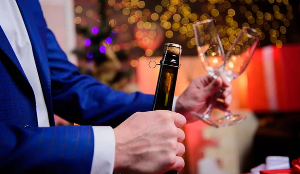 Ας το γιορτάσουμε. Αρσενικό χέρια άνοιγμα μπουκάλι σαμπάνιας ρίχνει γυαλιά Χριστουγεννιάτικη διακόσμηση φόντο. Πιείτε σαμπάνια ή αφρώδη οίνο. Γιόρτασε το νέο έτος με σαμπάνια. Τοστ και επευφημίες ιδέα — Φωτογραφία Αρχείου