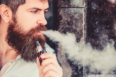 Sakallı adam duman dışarı nefes. Elektronik sigara sigara. Stres Rölyef kavramı. Sigara cihazı. Adam uzun sakal sigara alışkanlığı ile rahat. Aromalı duman bulutları. Sakallı adam sigara vape