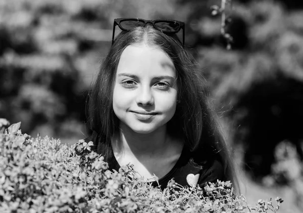 Natürliche Schönheit. Kinderglück. kleines Mädchen riecht blühende Blumen. glückliches Kind mit Buschblüte. Frühlingsferien. Frauentag. Sommerliche Natur. Den Frühling genießen — Stockfoto