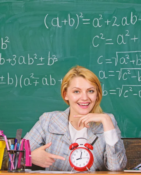 Confianza y puntualidad. Estudio y educación. Escuela moderna. Día del conocimiento. De vuelta a la escuela. Día del maestro. En la escuela. Enseñanza en casa. Mujer feliz. mujer en el aula. profesor con despertador. Tiempo. — Foto de Stock