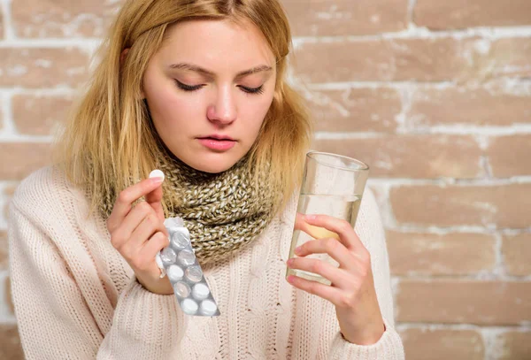 Maux de tête et médicaments contre la fièvre. Pilules pour briser la fièvre. Prenez des médicaments pour réduire la fièvre. Femme écharpe tousled cheveux tenir verre d'eau et comprimés blister. Fille se sent malade souffrir de fièvre et de prendre des médicaments — Photo