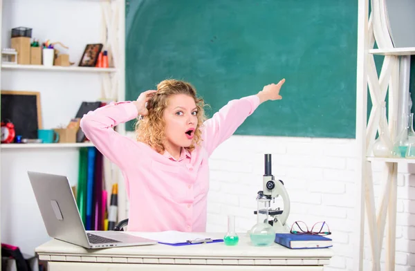 Duygusal insanlar kavramı. Dizüstü bilgisayar ve okul ekipmanları kırtasiye ile masada Kadın öğretmen veya öğrenci. Sınıf tebeşir tahtası arka planda Duygusal kadın öğretmen eğitimci. Duygusal kontrol