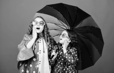 Parlak şemsiye. Mutlu çocukluk. Birlikte mutlu olmak daha kolay. Birileri bulut gökkuşağı olun. Uygun giysiler ile yağmurlu hava. Şemsiyenin altında yürü. Şemsiye altında Çocuk kızlar mutlu arkadaşlar