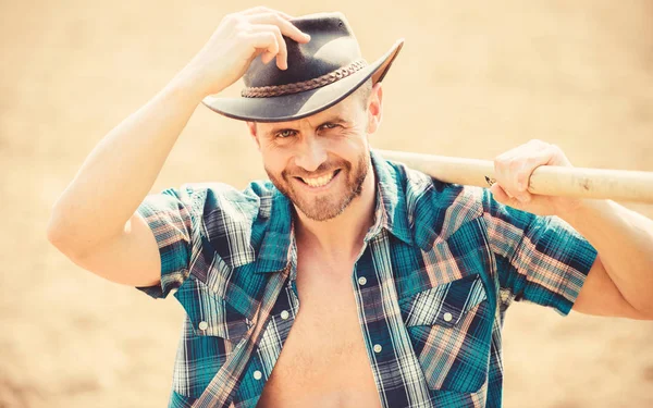 sexy farmer hold shovel. Eco farm. Harvest. happy earth day. Eco living. farming and agriculture cultivation. Garden equipment. muscular ranch man in cowboy hat. Enjoying his work