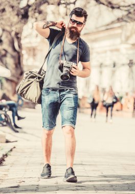 Elle ayarlar. Sakallı ve bıyıklı bir fotoğrafçı. Turist fotoğrafları. İçerik yaratan. Sakallı hippi fotoğrafçı. Eski ama yine de iyi. Fotoğrafçı klasik fotoğraf makinesini tutar. Modern blog yazarı