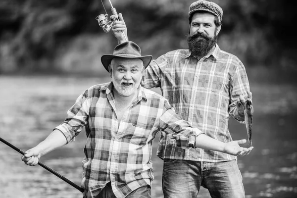 Concetto di fuga rurale. hobby. Tempo di pesca a mosca. due pescatori felici con canna da pesca e rete. Campeggio sulla riva del lago. turismo di caccia. padre e figlio pesca. Pesca d'altura. amicizia — Foto Stock