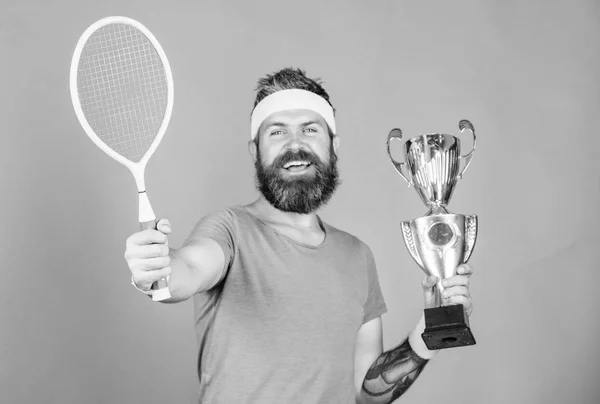 Ningún jugador puede pisar la cancha contra mí y sentirse seguro. Jugador de tenis gana el campeonato. Atleta hipster sostener raqueta de tenis y copa de oro. Gana un partido de tenis. Hombre barbudo hipster desgaste traje deportivo —  Fotos de Stock