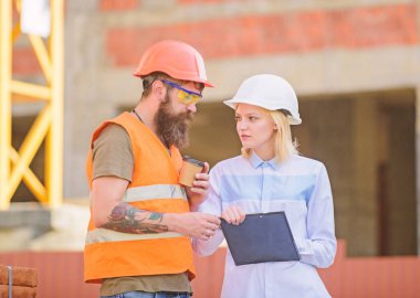 Kadın mühendis ve inşaatçı şantiye iletişim. İlerleme planını tartışın. İnşaat müşterileri ve katılımcı inşaat endüstrisi arasındaki ilişkiler. İnşaat ekibi iletişim konsepti