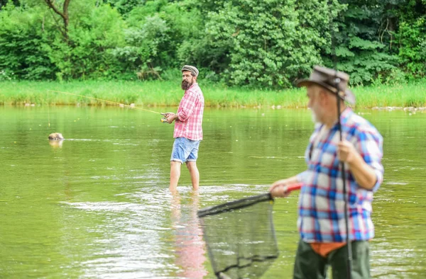 Que tem mais. Filho e pai a pescar. amizade masculina. ligação familiar. Fim de semana. dois pescadores com varas de pesca, foco seletivo. Homem maduro pescador. hobby e atividade esportiva — Fotografia de Stock