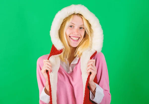 Woman emotional face posing in warm furry hood. Winter time for cozy warm accessories. Lets stay warm in fur clothing. Girl cheerful blonde warming up wear fur hood on green background
