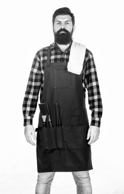 Açık havada yemek pişirme. Sakallı adam ceplerinde ızgara tutucu araçları ile apron giyiyor. Barbekü ızgara için metal eşyaları ile hipster. Mangal aşçımız. Barbekü seti kullanarak ızgarada yiyecek hazırlama