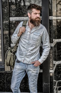 Omuzlarında büyük çantada bir şeyler taşı. Sakallı ve bıyıklı kaslı adam büyük sportif çanta taşıyor. Seyahat ve tatil konsepti. Turist bagaj ile şehir keşfetmek. Omzunda ağır çanta