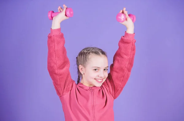 Glad barnidrottsman med hantel. träning av liten flicka hålla hantel. tyngdlyftning för muskler. Barndomsverksamhet. Fitness kost för energi hälsa. Idrottsframgång. Träning med hantlar — Stockfoto