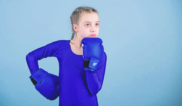 Contrariamente allo stereotipo. Boxer bambino con i guanti da boxe. Le pugili cambiano atteggiamento nello sport. Aumento delle donne pugili. Ragazza simpatico pugile su sfondo blu. Con grande potere viene grande responsabilità — Foto Stock