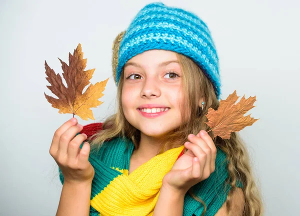 Kid hord meleg kötött kalap és a hosszú sálat. Őszi divat koncepció. Melyik szövet fogja Önt legmelegebb idén ősszel. Meleg gyapjú kiegészítők. Lány boldog arc fehér háttér. Kalap és sálat melegen tartani — Stock Fotó