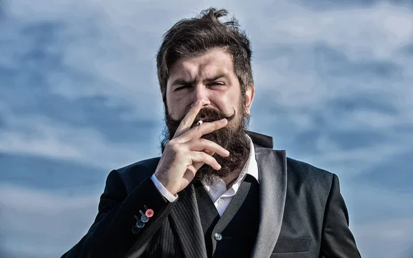 Homme fumant. brutal hipster caucasien avec moustache. Un barbu fumant de la cigarette. fumée. Hipster mature avec barbe. Succès futur. Mode masculine formelle. Homme d'affaires contre le ciel — Photo