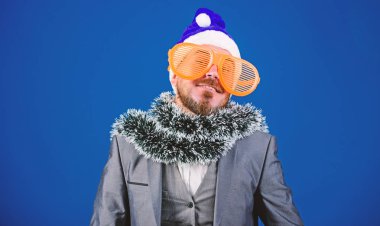 Kurumsal Noel partisi. Sakallı adam hipster giymek santa şapka ve komik güneş gözlüğü. Noel partisi organizatörleri. Adam tinsel hazır yeni yıl kutlama. Şirket parti fikirleri çalışanlar seveceğim