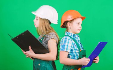 okul projesi. küçük kızlar atölyede birlikte tamir. İşçi bayramı. 1 mayıs. Tabletli kasklı küçük çocuklar. Foreman müfettişi. Onarım. okul proje kavramı. çocuklar okul projesi için çalışmak