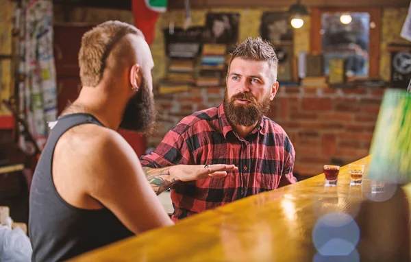 Friday relaxation in bar. Friends relaxing in bar or pub. Soulmates drunk conversation. Hipster brutal bearded man spend leisure with friend at bar counter. Men relaxing at bar. Strong alcohol drinks