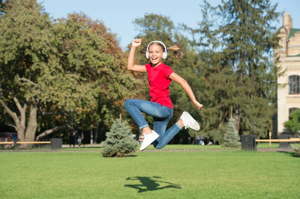 Nooit stoppen. Meisje luisteren muziek moderne gadget. Kid met draadloze headset dansen Running jumping. Stereohoofdtelefoon. Kid met moderne technologie. Modern kind. Perfect geluid. Opportunities uitvouwen — Stockfoto