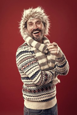Kahkaha atıyorum. Sakallı adam şapka ve eşarp ile kazak accessorizing. Bir kış topluluğu onu soğuktan korur. İnsan için kışlık gardırop. Soğuk hava tarzında olgun model, vintage filtre