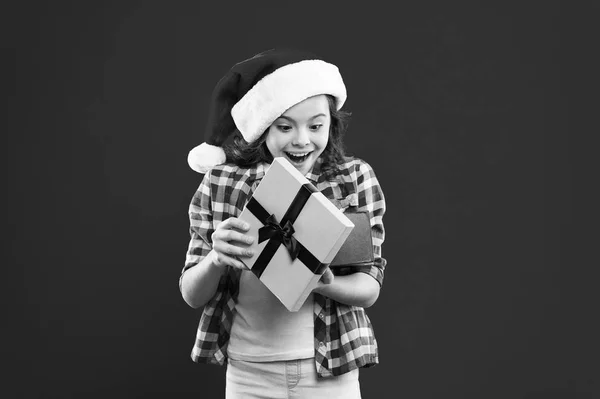 С зимними праздниками. Это для меня. Маленькая девочка. Подарок на Рождество. Детство. Рождественские покупки. Маленькая девочка в красной шляпе Санты. Новогодняя вечеринка. Малыш Санта Клауса. Время Рождества — стоковое фото
