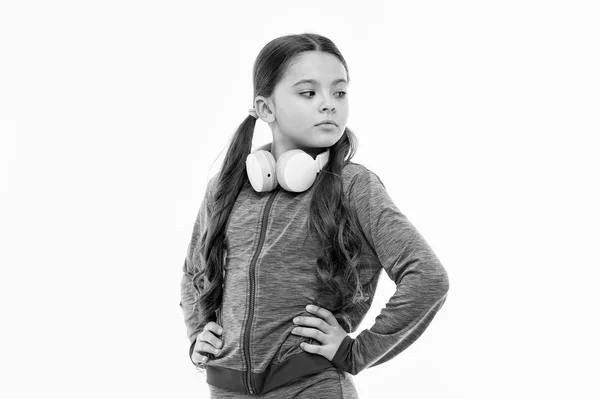 音楽に浸る。白で隔離愛らしいヘッドセットユーザー。調節可能な白いヘッドセットを身に着けている小さな子供。ワイヤレスブルートゥースヘッドセットを持つ小さな女の子。音楽リスニングにステレオヘッドセットを持つかわいい子供 — ストック写真