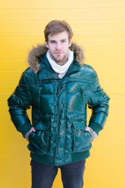Soğuk mevsim için geliştirilmiş koruma. Moda modeli sıcaklık ve konfor zevk. Kapüşonlu palto giyen yakışıklı bir adam. Soğuk hava tarzında moda adam. Soğuk kış koşulları için gündelik moda ceket