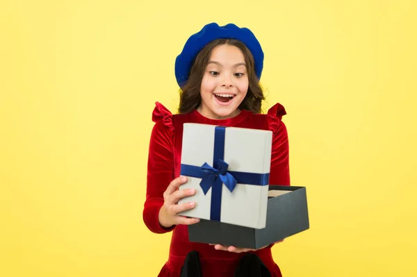 Comprando felicidad. sorprendido niña pequeña con caja de regalo. Niña pequeña celebrar regalo de vacaciones. Feliz cumpleaños. día de boxeo. chica parisina en boina francesa ir de compras. moda de otoño. escuela otoño temporada —  Fotos de Stock