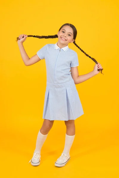 Ανέμελη μαθήτρια. μικρό κορίτσι με σχολική στολή. ρετρό εμφάνιση. παιδί σε vintage στυλ. παλιάς σχολής. Παιδική μόδα. ευτυχισμένο παιδί σε κίτρινο φόντο. Μόδα και την ομορφιά. Παιδική ευτυχία. αστεία διάθεση — Φωτογραφία Αρχείου