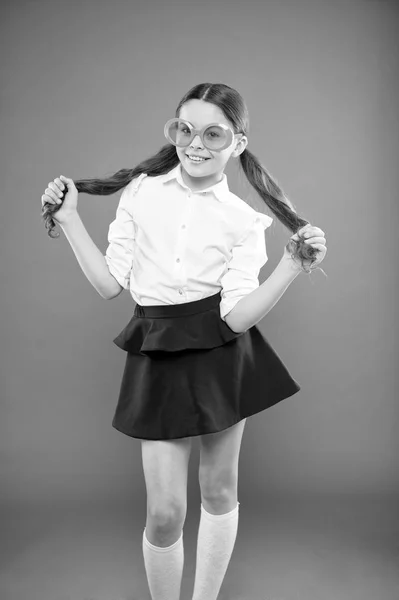 Én vagyok a lány, és én vagyok okos. Kis okos iskolás a narancssárga háttérben. Imádnivaló gyermek, okos Nézd át díszes szemüveget. Divatos kis gyerek napszemüveget visel az intelligens és elegáns stílusban — Stock Fotó